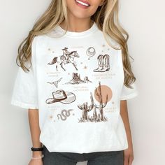 Step into the wild, wild west with our Western Cowgirl Graphic Tee! The vintage style on this Comfort Colors t-shirt is a must-have for any cowgirl at heart. This tee is perfect for adding a touch of western aesthetic to your wardrobe. Whether you're looking for a fun graphic tee for yourself or to gift to a best friend our Cowgirl Tee is the perfect choice! Make sure to size up for that trendy oversized look! Features: 100% ring spun cotton, 30 singles Garment dyed for that lived in feel and al White Crew Neck Tops For Western-themed Events, Country Style Short Sleeve Tops For Western-themed Events, Retro T-shirt For Western-themed Summer Events, Retro Summer T-shirt For Western-themed Events, Casual White T-shirt For Western-themed Events, Trendy White Tops For Ranch, Graphic Tee With Screen Print For Western-themed Events, Summer Crew Neck T-shirt For Western-themed Events, White Graphic Print T-shirt For Western-themed Events