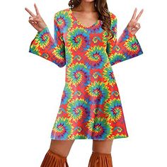 a woman in a colorful dress and boots posing with her hands up to the side