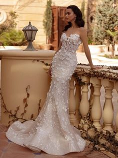 a woman in a wedding dress standing on a balcony