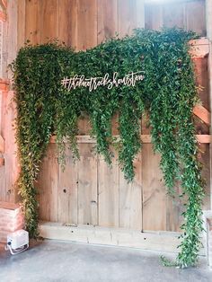 a wooden wall covered in green vines and the words, wedding station written on it