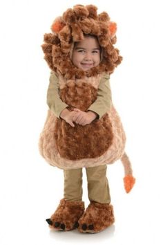 a little boy in a lion costume standing with his arms around the back of a stuffed animal