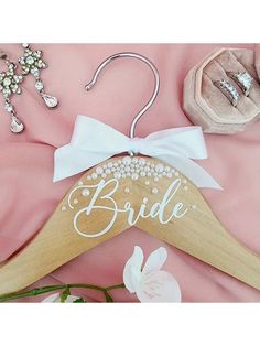 a wooden hanger with the word bride written on it next to other wedding accessories