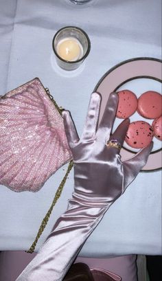 a person's hand is shown next to some cookies and a candle on a table