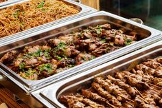 many different types of food in metal trays on display at a buffet or restaurant