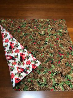 a table cloth with pine cones and holly on it