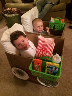 two small children in boxes on the floor