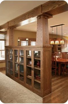 an open kitchen and dining room area with wood flooring, built in bookcases