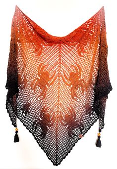 an orange and black crocheted shawl with tassels