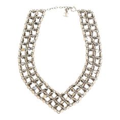 This is part of Chairish’s Costume Jewelry assortment.   This hot fabulous rock stud Chanel signed necklace is in the shape of a V on your neck. It is signed Made in France Chanel '98. It is silver toned metal and each side has 3 rows of studs that are connected. There are many cc's on the final back row. There is also a dangling CC at the back of your neck. This is from 1998. One can make this closer to the neck as in a collar look as there are 12 links to choose from to make it higher up on yo Luxury Silver Metal Choker, Luxury Silver Choker Chain Necklace, Designer Metal Necklace For Party, Luxury Silver Metal Necklace, 1990s Chanel, Chanel Sign, V Necklace, Chanel Necklace, Back Row