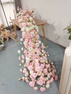 pink and white flowers are arranged on the floor