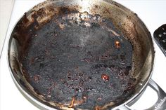 a pan that has some kind of food inside of it on the stove with two remotes next to it