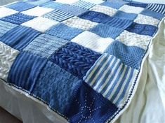 a blue and white blanket on top of a bed