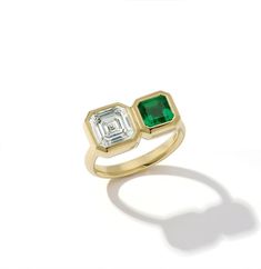 an emerald and diamond ring on a white background