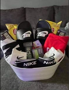 a white basket filled with nike slippers and other personal items on top of a couch