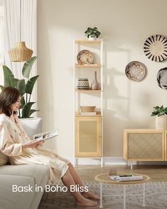 a woman sitting on top of a white couch in front of a book shelf filled with books