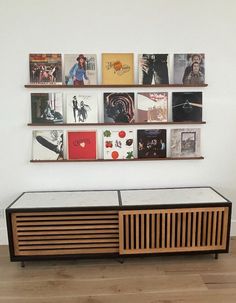 an entertainment center with various records on the wall