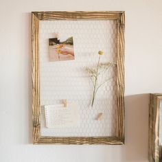 an old frame with some flowers and pictures on it next to a wall mounted photo