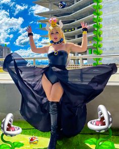 a woman in a black dress and boots posing for the camera with her legs spread out