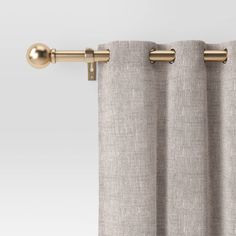 an open curtain with gold hardware on the top and bottom, in front of a white background