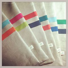 four white towels with different colored stripes on them