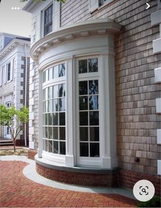 an arched window on the side of a brick building in front of a red brick sidewalk