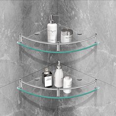 three tiered glass shelf with soap and lotion on the bottom, in front of a marble wall