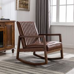 a brown rocking chair sitting on top of a rug