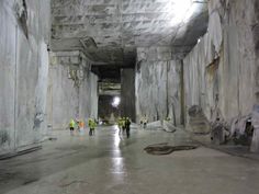 people in yellow vests are walking through a tunnel