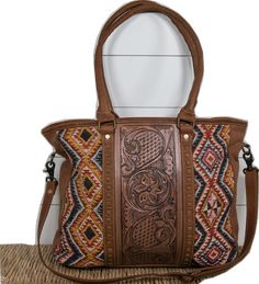 Brown Hand Tooled Shoulder Bag, Brown Hand-tooled Satchel For Travel, Brown Hand Tooled Satchel For Travel, Hand Tooled Brown Satchel For Travel, Brown Hand Tooled Shoulder Bag For Everyday Use, Brown Hand-tooled Double Handle Bags, Brown Hand Tooled Tote Shoulder Bag, Brown Hand Tooled Shoulder Bag For Travel, Hand Tooled Brown Travel Bag