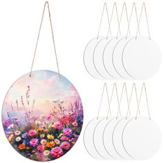 six white round wall hangings with flowers painted on the front and back of them