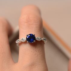 a woman's hand with a blue ring on it