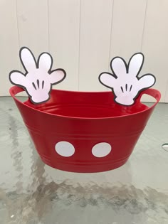 a red bucket with mickey mouse cutouts on the top and two minnie mouse ears sticking out of it