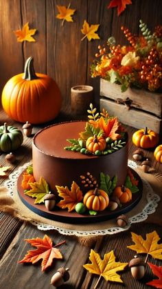 a chocolate cake decorated with leaves and acorns sits on a table surrounded by fall decorations