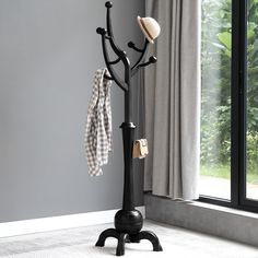 a coat rack with two hats hanging from it's sides and an umbrella on top