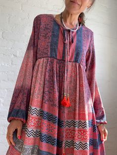 "This is very cute and beautiful light silky tunic dress with floral print in delicate grey and pink colours true boho chic style it is made loose and flared with high waist and long puff sleeve  effortles to wear and easy fitting to all shapes perfect outfit for many occasions parties dinners birthday, great maternity outfit 😊 MEAESURE size M/L shoulders 17\" bust up to 37\" ( it is front tie srap, so can be easyli loosen up or tighten ) high waist 36\" length 40\" MATERIAL *mixed silk, no lin Spring Boho Maxi Dress With Back Tassel Tie-up, Spring Maxi Dress With Back Tassel Tie-up, Bohemian Non-stretch Long Maxi Dress, Long Bohemian Dress With Back Tassel Tie-up, Chic Flowy Rayon Boho Dress, Printed Long Sleeve Relaxed Fit Dress, Spring Dresses With Back Tassel Tie-up, Non-stretch Bohemian Maxi Dress, Pink Floral Print Dress With Relaxed Fit