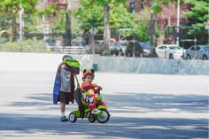 a young boy riding a tricycle next to an adult