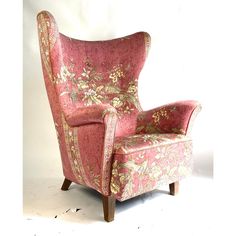 a pink and gold chair with floral fabric