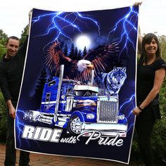 two people standing next to a blue truck with an eagle and wolf on the front