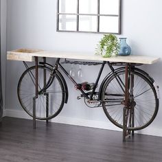 a bike is parked next to a table with a mirror on it's wall