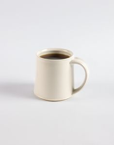 a white coffee cup filled with dark liquid