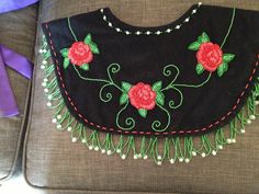 an embroidered black purse with red roses on it