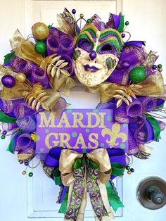 a mardi gras wreath is hanging on the front door with a sign that says mardi gras