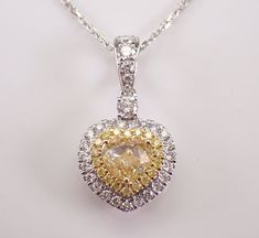 18K White Gold Canary Diamond Heart Pendant with Chain. This pendant is set with a center natural Heart shaped Brilliant Diamond, eighteen Round Brilliant side Canary Diamonds and thirty-one Round Brilliant White/Colorless Diamonds. The Yellow Canary Heart shape center Diamond is SI1 in clarity and weighs 1.00 carat.  The rest of the Fancy Yellow Diamonds are SI/I1 in clarity and amount to a total of .11 carats. The White Brilliant diamonds set in this pendant are H color, SI clarity and weigh a total of .41 carat.  The total diamond weight of this necklace is 1.52 carat. This pendant is 18KT White and Yellow Gold (the yellow diamonds are set in yellow Gold), comes with an 18" 18KT White Gold chain (that has diamond stations on the chain) and together weighs 4.5 grams. The pendant alone me White Gold Heart Cut Diamond Necklace With 17 Jewels, Gia Certified Heart-shaped Diamond Jewelry, Luxury Heart Cut Gia Certified Jewelry, Luxury Gia Certified Heart Cut Jewelry, Exquisite Diamond Cut Heart Shaped Jewelry, Fine Jewelry Gia Certified Heart-shaped, Fine Jewelry Heart-shaped Gia Certified, Exquisite Heart Cut Diamond Jewelry, Gia Certified Heart-shaped Jewelry For Valentine's Day