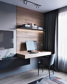 a desk with a computer on top of it in front of a wall mounted tv