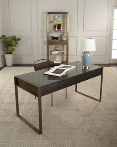 a living room with a table, chair and lamp on the floor in front of a bookcase