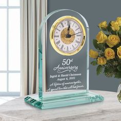 a vase filled with yellow roses next to a clock