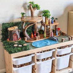 a wooden toy house with lots of toys on it's shelf and storage bins