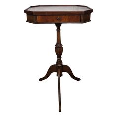 an antique wooden table with glass top