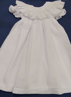 Hand smocked white dress with ruffle collar and delicate flowers. Size 2T is available $70.00 Prices varies according to size. For other sizes allow 3 to 4 weeks for delivery. This dress is an Easter dress, portraits or flower girl or any other special occasion. For custom orders allow 4 weeks for delivery. White Ruffle Dress For Spring Wedding, Elegant Fitted Smocked Dress With Lace Trim, White Ruffle Hem Dress For Wedding, White Ruffle Hem Wedding Dress, Elegant Fitted Ruffle Dress For Dress-up, Elegant White Smocked Dress With Lace Trim, Formal White Ruffled Dress, Elegant Smocked Ruffle Dress For Baptism, Elegant Smocked Dress With Flutter Sleeves