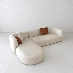 a large white couch with two pillows on it's back and one pillow on the side